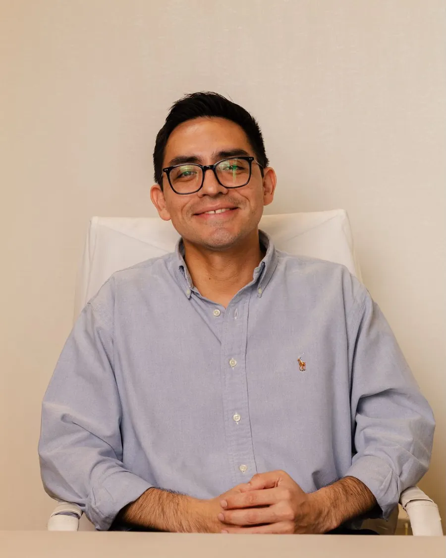 Dr. Eliel Orozco, dermatólogo pediatra, sonriendo en su consultorio
